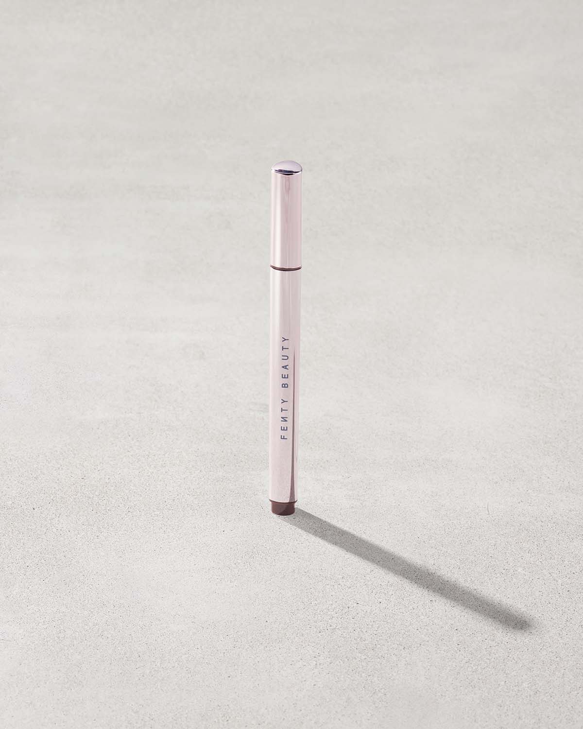 Fenty Beauty Flyliner Longwear Liquid Eyeliner in shade In Big Truffle on concrete background