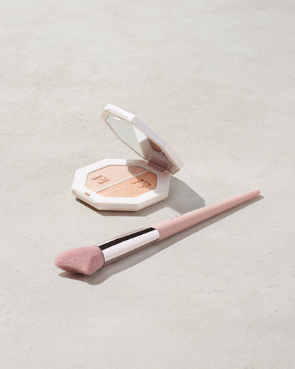 imagery of killawatt freestyle highlighter in shade lightning dust/fire crystal on a concrete background with the cheek hugging highlight brush