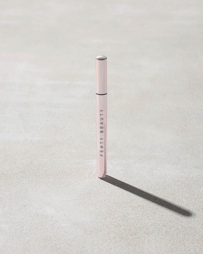 Closed Flyliner Longwear Liquid Eyeliner standing on a light grey concrete surface. The exterior showcases a chic light metallic pink finish.