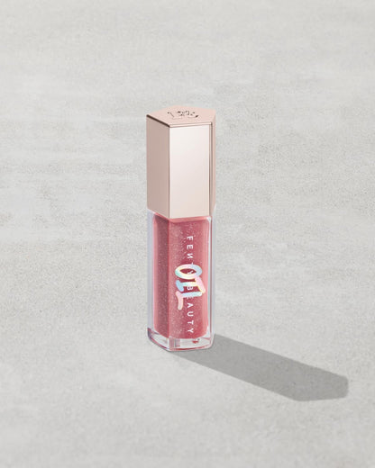 Gloss Bomb Oil Luminizing Oil and Gloss in shade Fussy product against a concrete background.