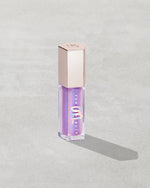 Gloss Bomb Oil Luminizing Oil and Gloss in shade Miss Jellyfish product against a concrete background.