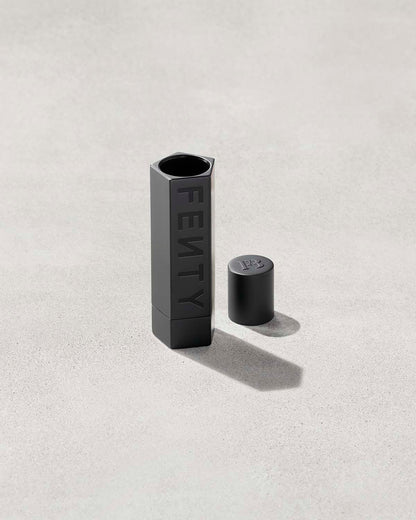 An open Fenty Icon refillable lipstack case in matte black.