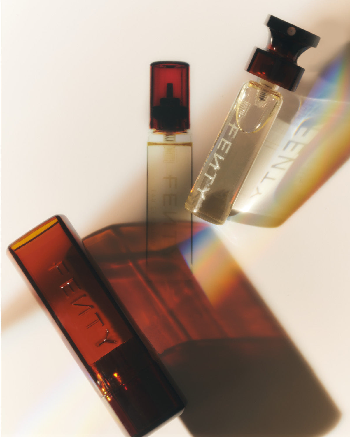 Fenty Eau de Parfum bottle and the refill bottle placed against a cream background with their shadows behind them.
