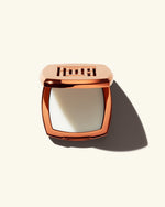 Open shot of Fenty Fragrance Solid Parfum on a cream background