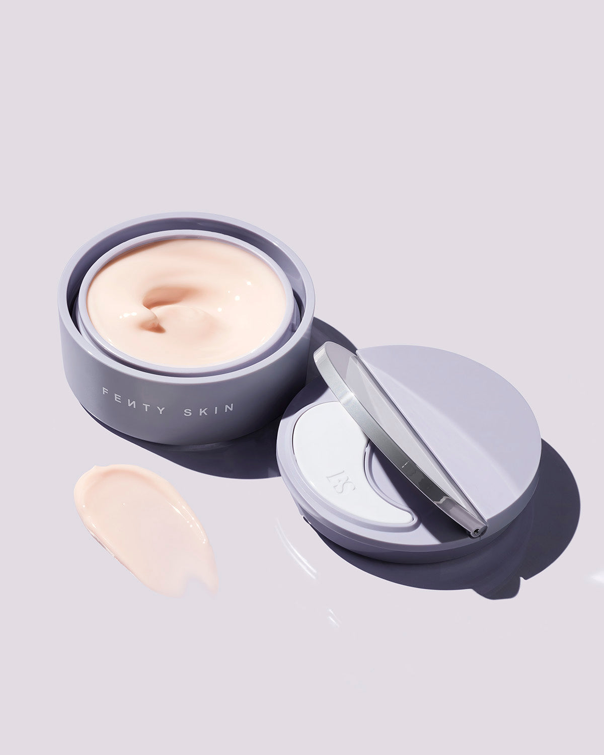 Instant Reset Gel container opened next to its lid, showing the applicator, on a lilac background.