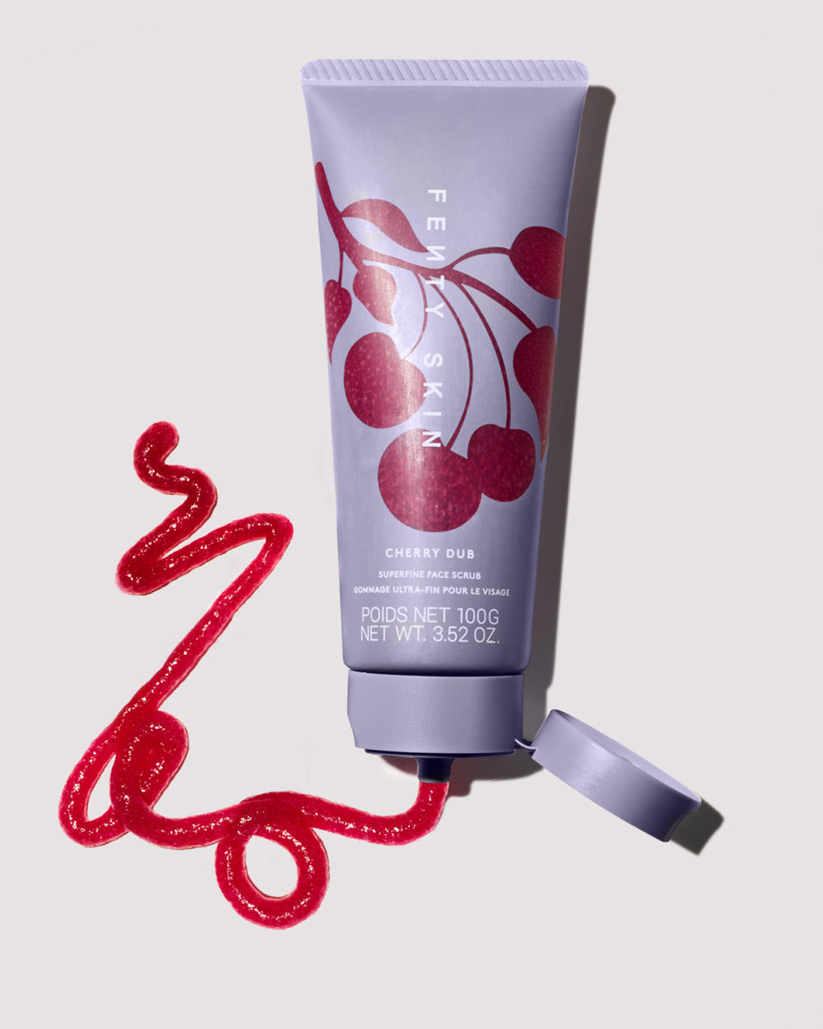 One open bottle of Cherry Dub Superfine Daily Face Scrub squirting some of the product on a light background.