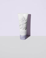 Cookies and clean face scrub product shot on a lavender background.